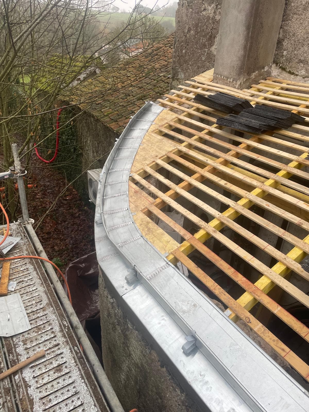 Chéneau cintré en zinc sur une toiture arrondie